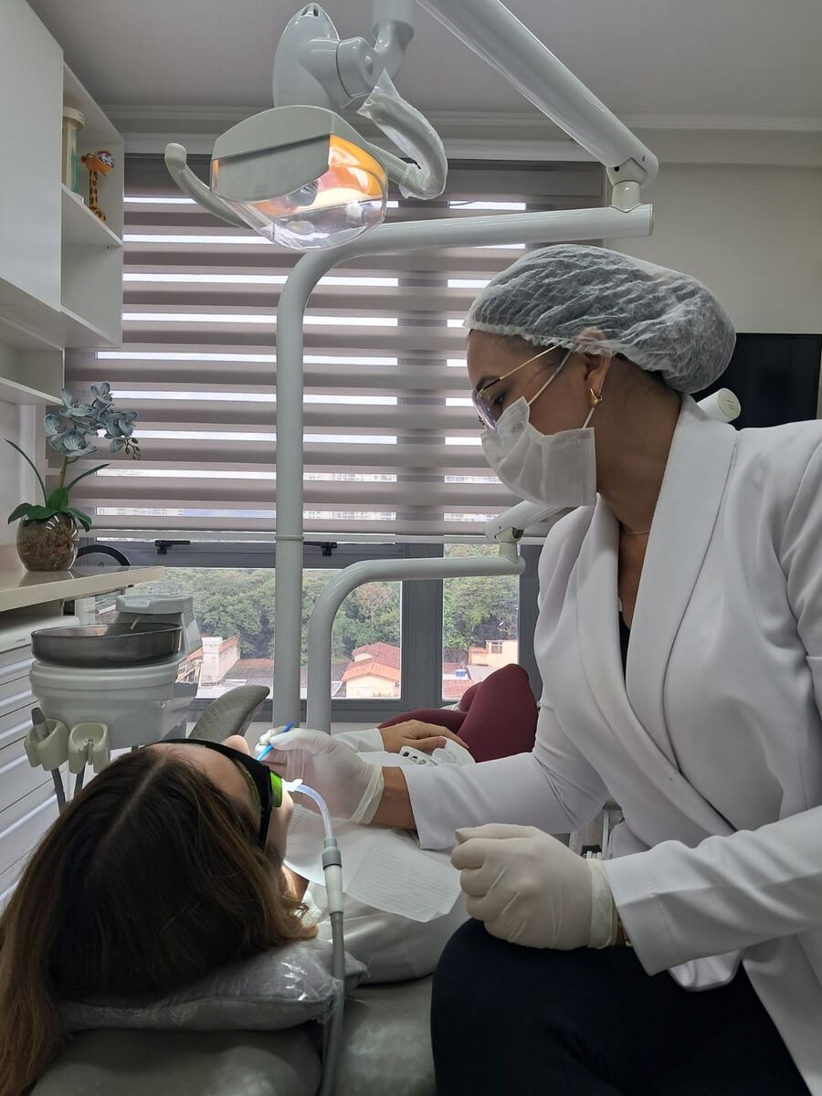 Dra. Mara Gama em atendimento odontológico no consultório